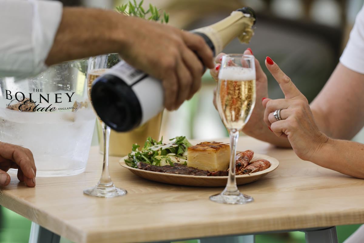 Waiter pouring champagne in glass for diner