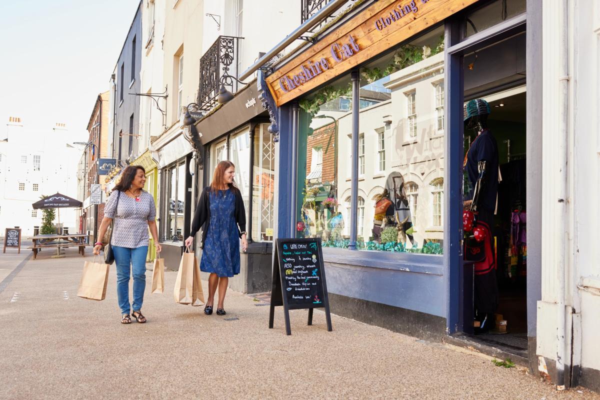 Two people walking past a shop in the pedestrain area of Carlton Place