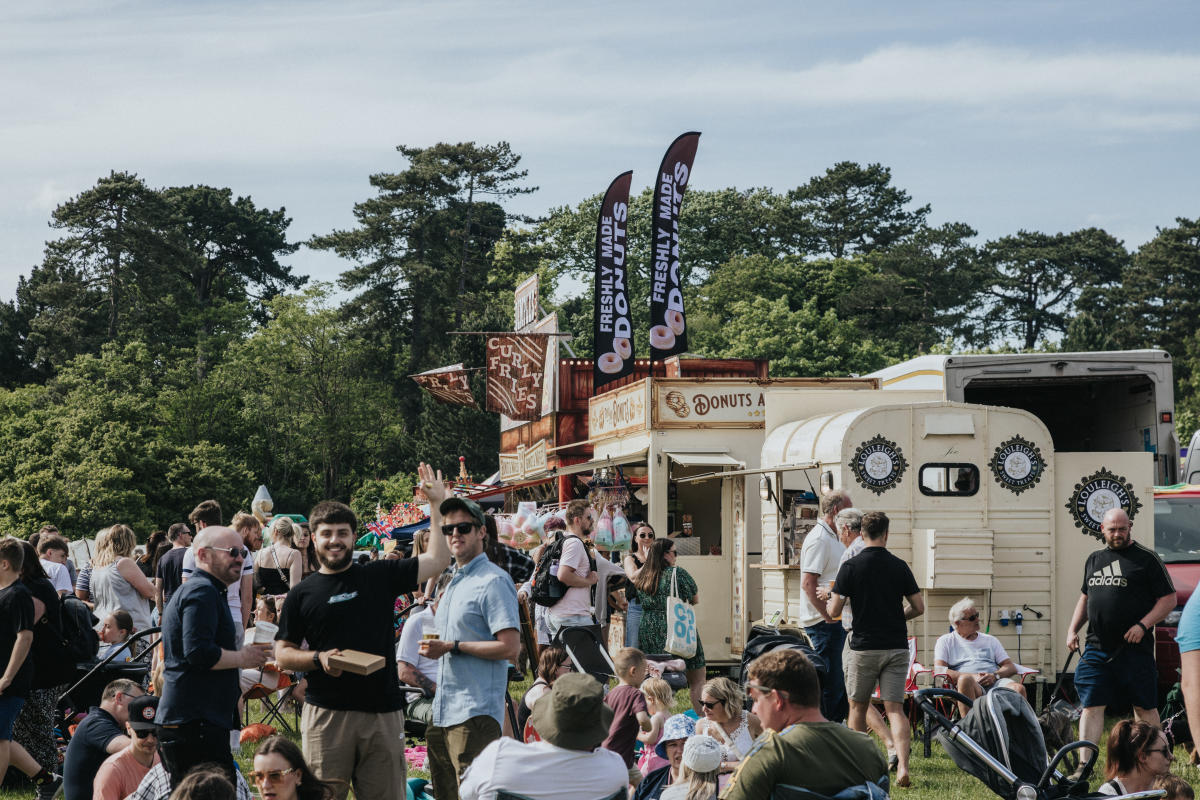 Man waving to camera holding food at The Big Eat Festival