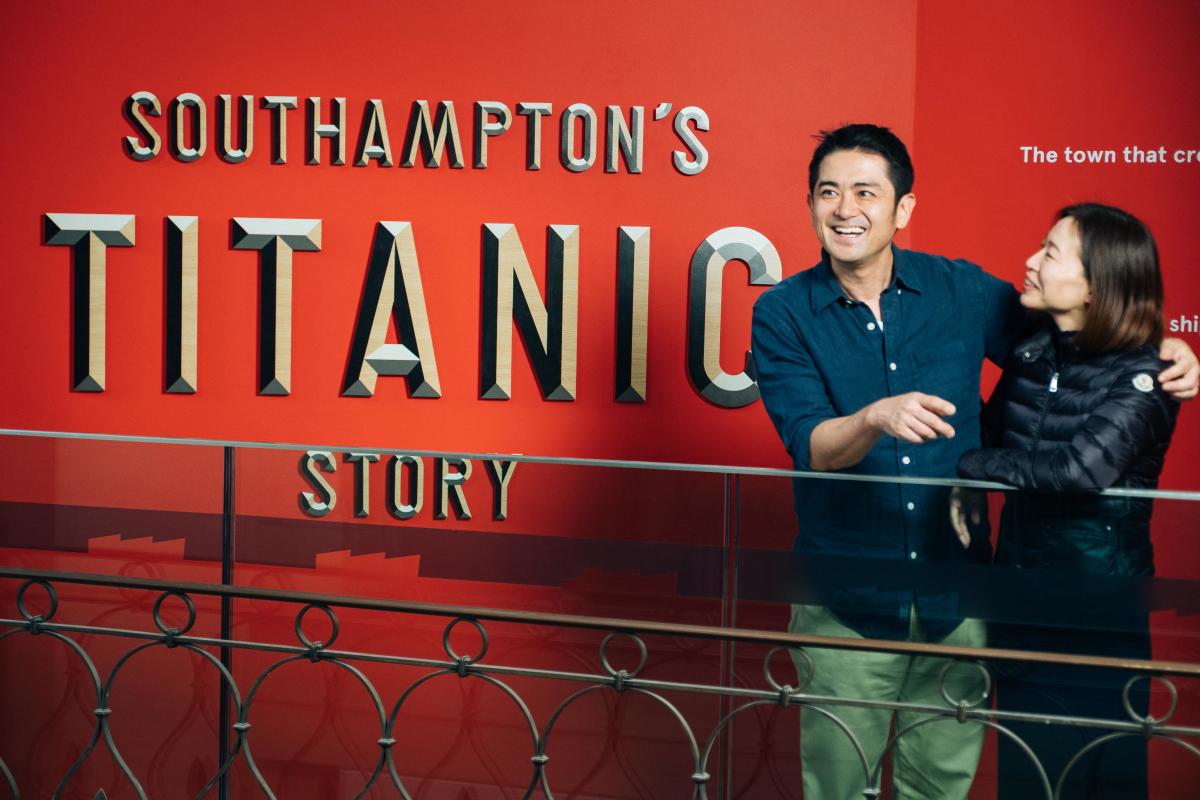 Two people stood in front of the Titanic Exhibition sign which reads Southampton's Titanic Story at Seacity Museum