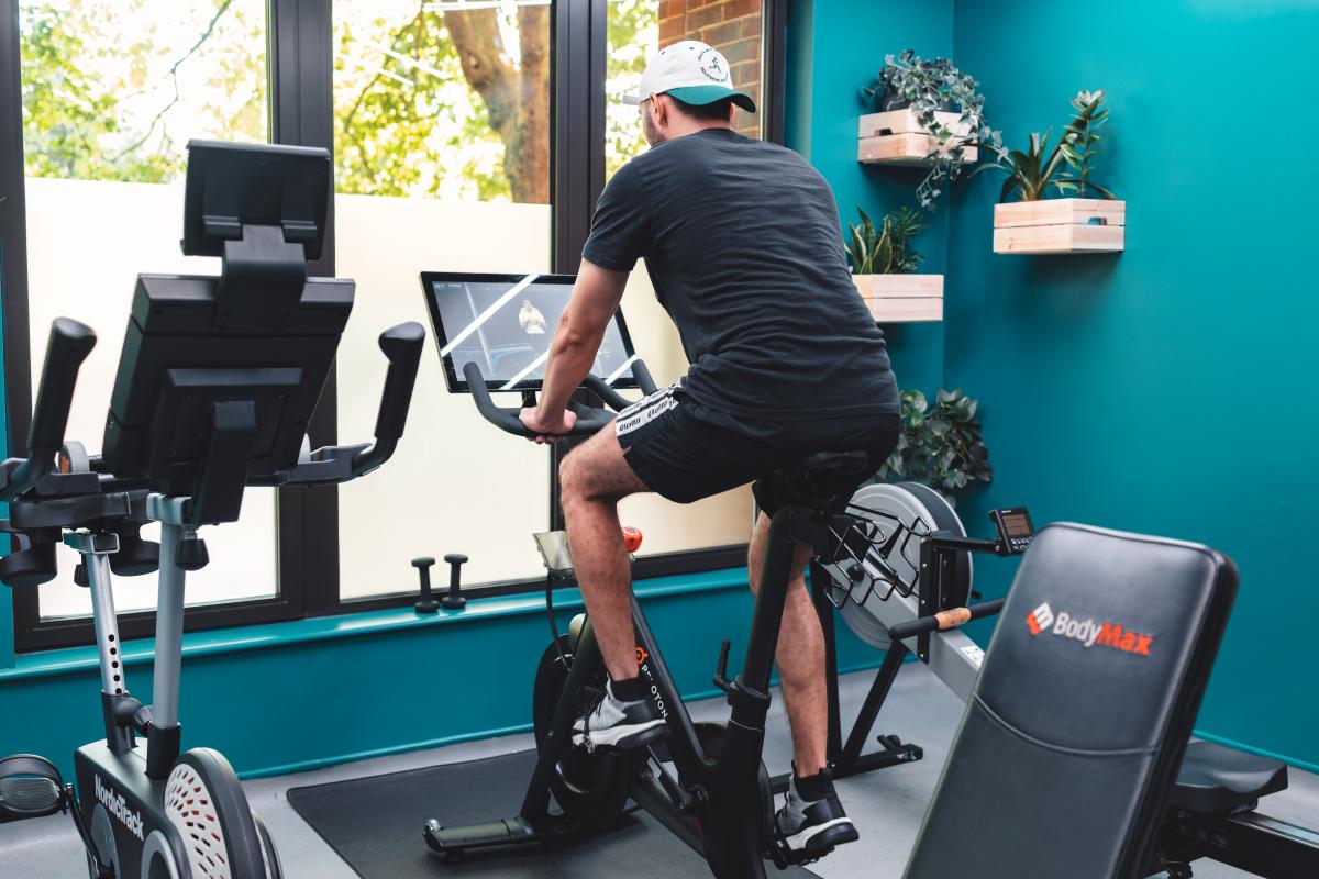 Man using exercise bike in room2's gym