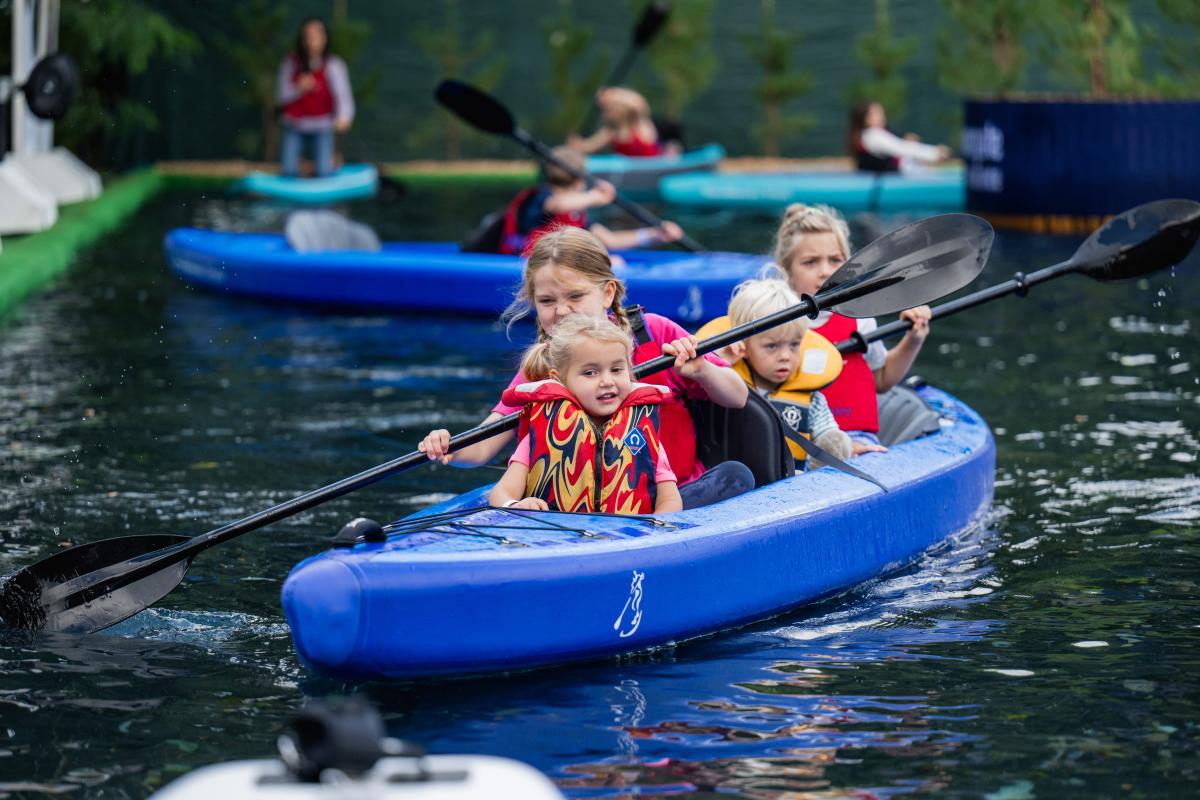 Kids paddling in kayak on water at Southampton International Boat Show