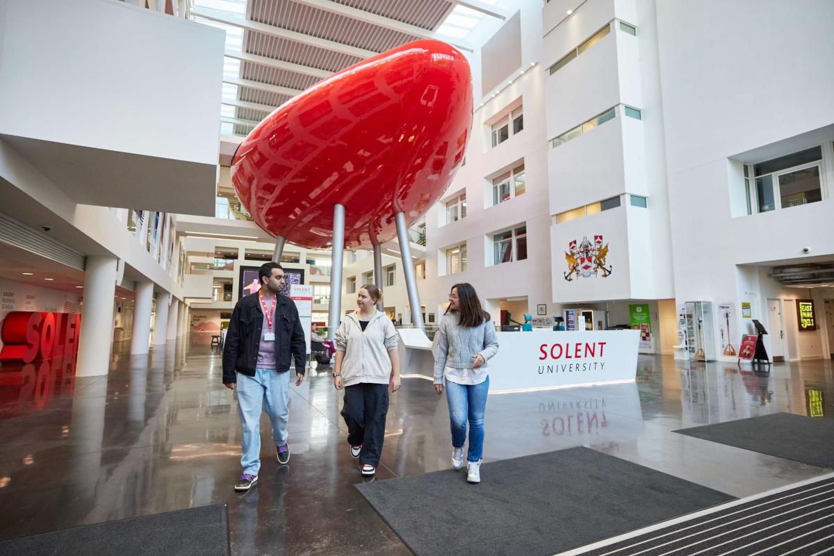 Solent University students walking in the Spark building
