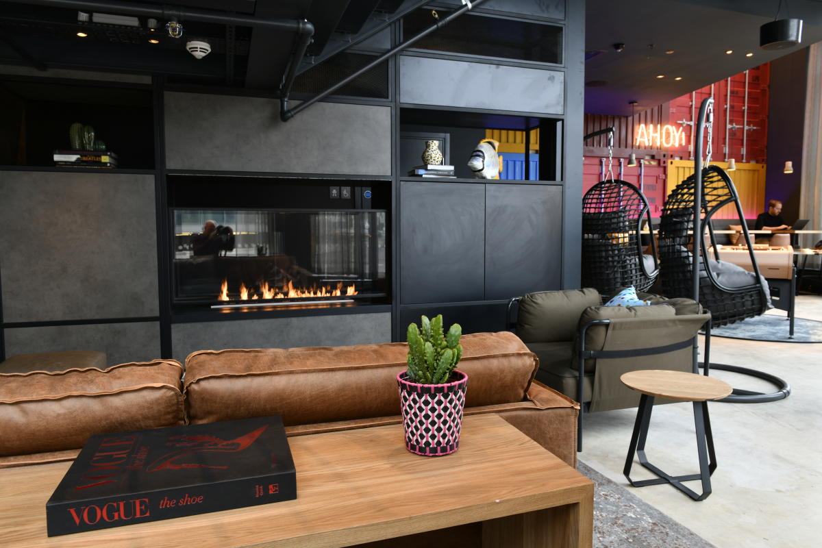 Moxy hotel sitting area with cosy fireplace, sofas and coffee table