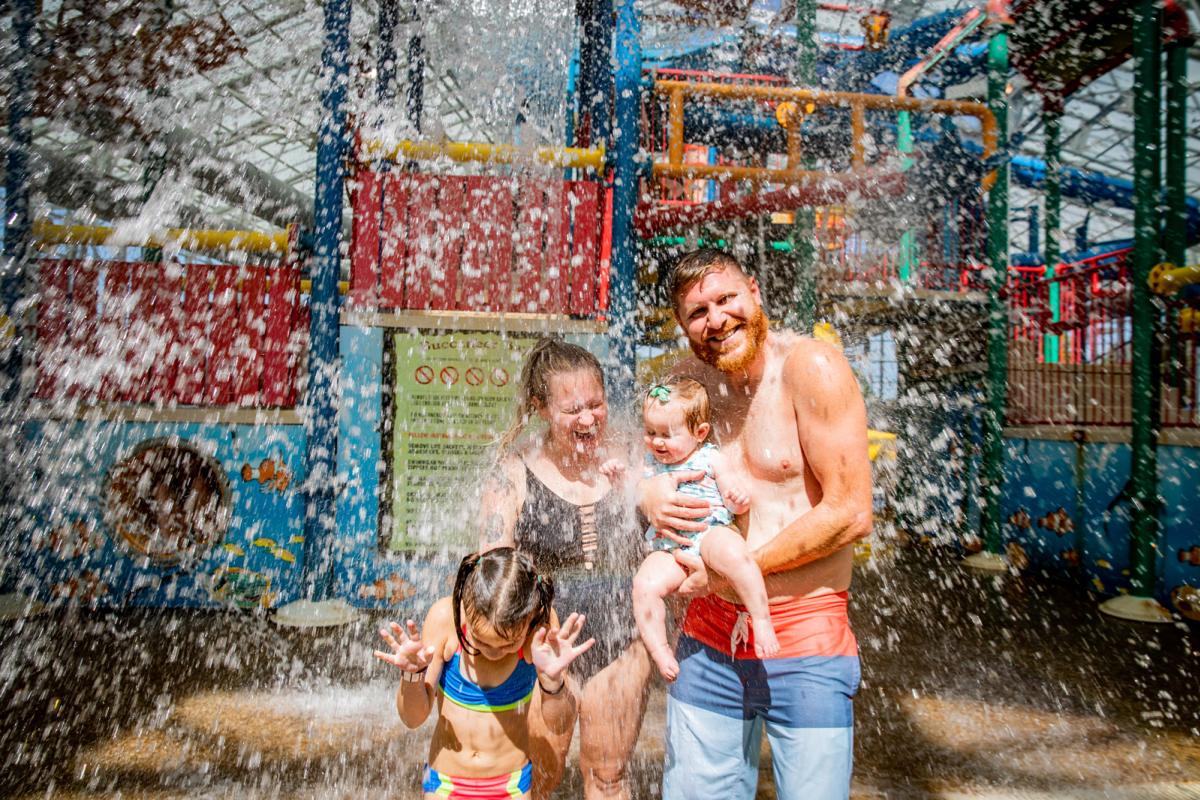 A family under at a water park being splashed with water