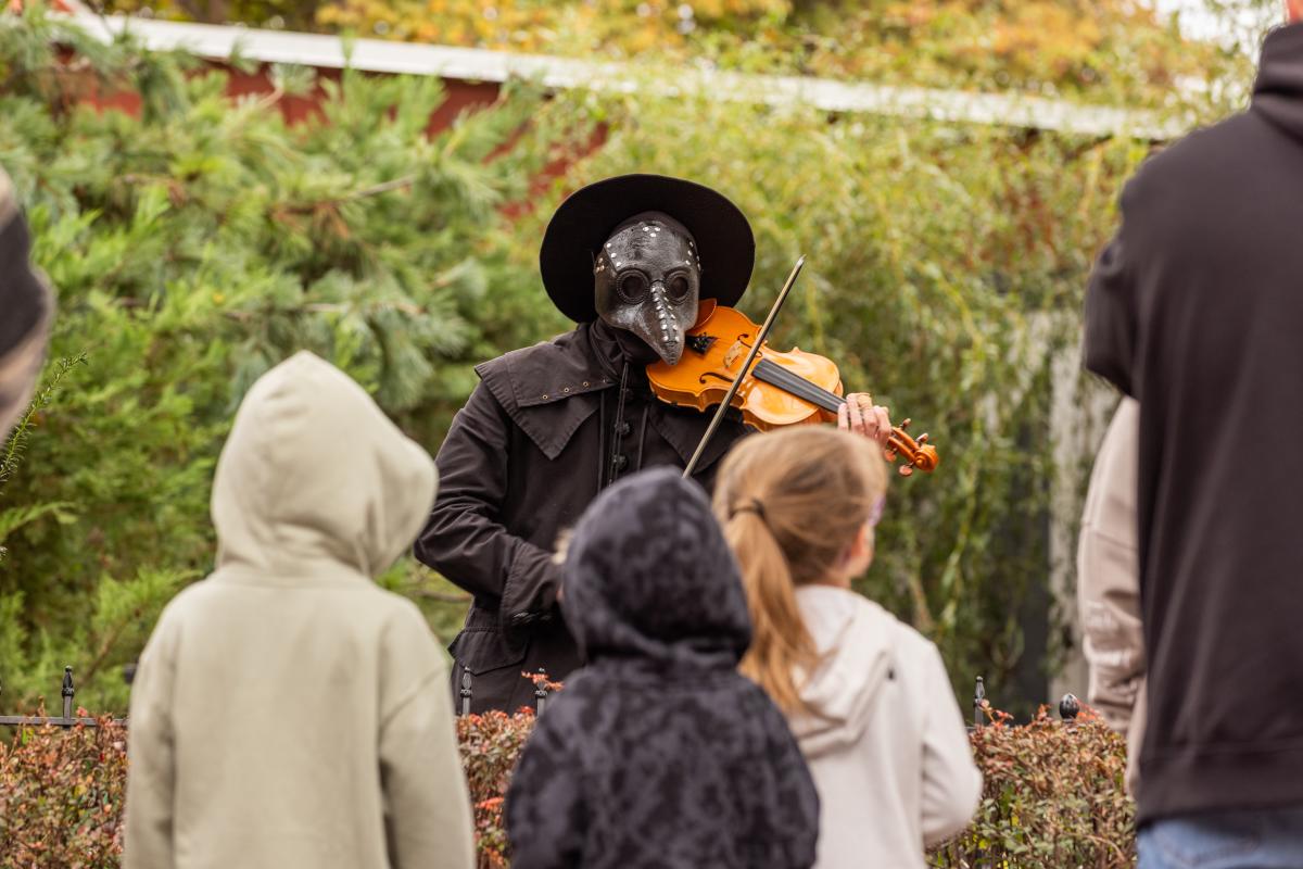 A character from Legends & Lanterns plays the violin on Historic Main Street in St. Charles, MO.