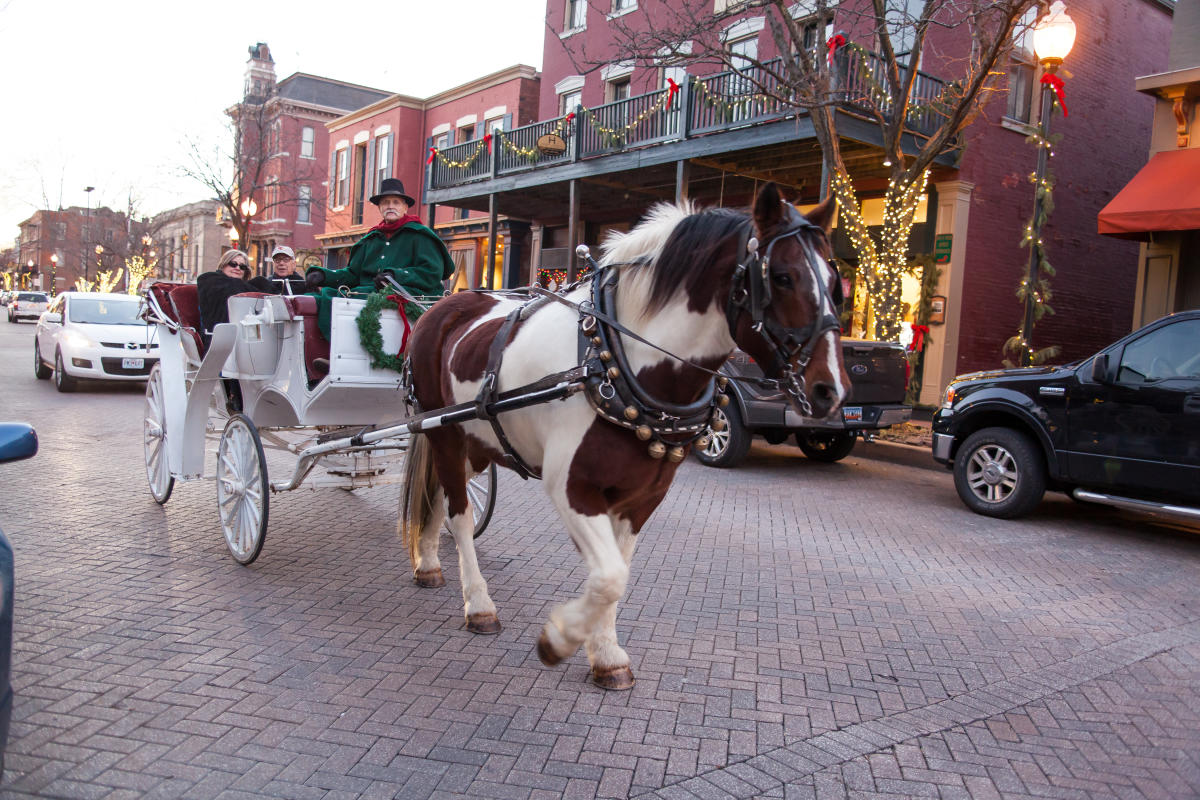 Christmas themed horse and carriage strolling down St. Charles Main Street