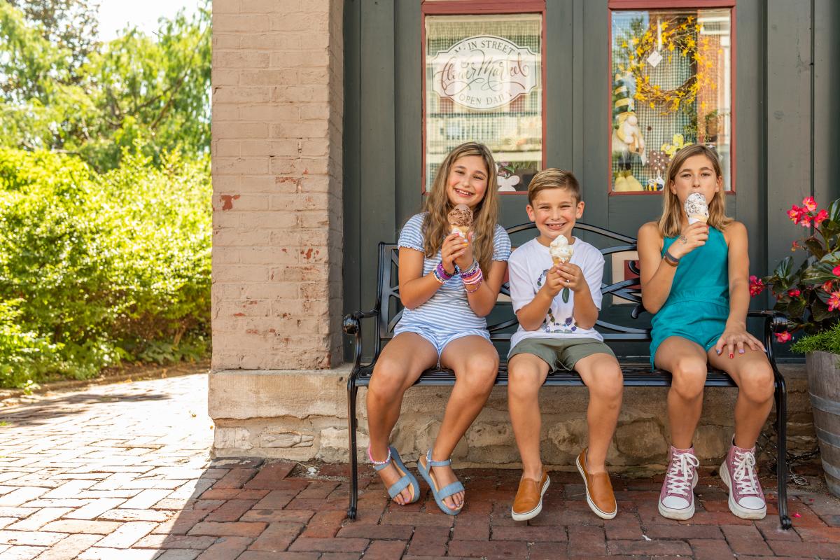 Three kids eating ice cream cones on Main Street in St. Charles, Missouri.