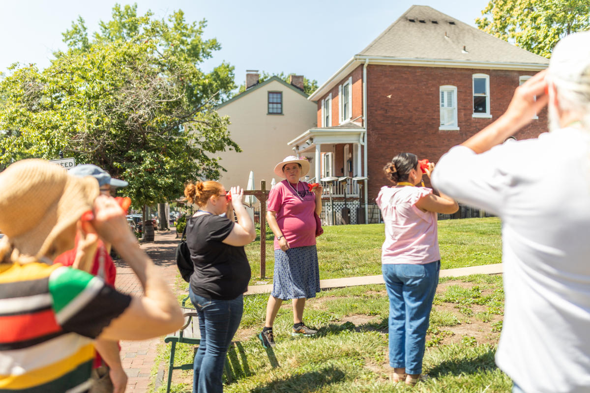A group of people look through ViewMasters on a Hit the Bricks tour on Main Street in St. Charles, Missouri.
