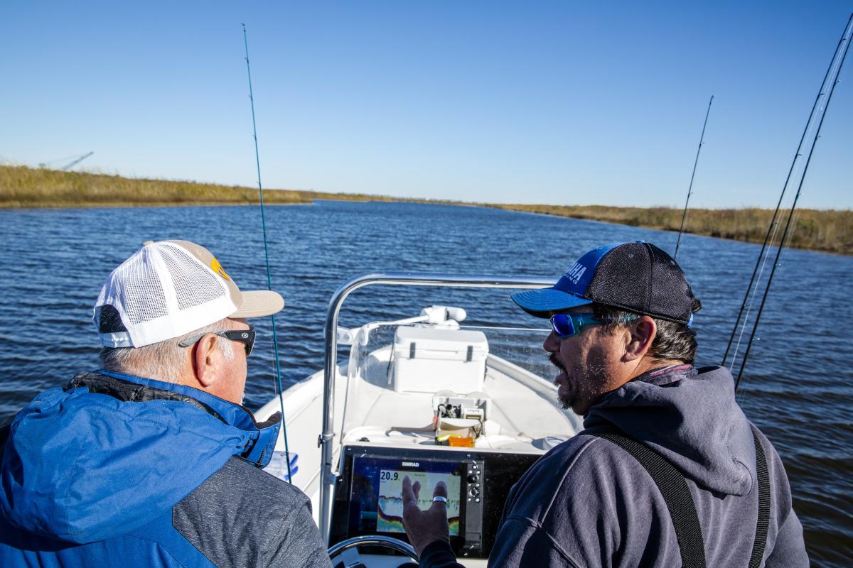 Two men speaking while on a charter fishing boat.