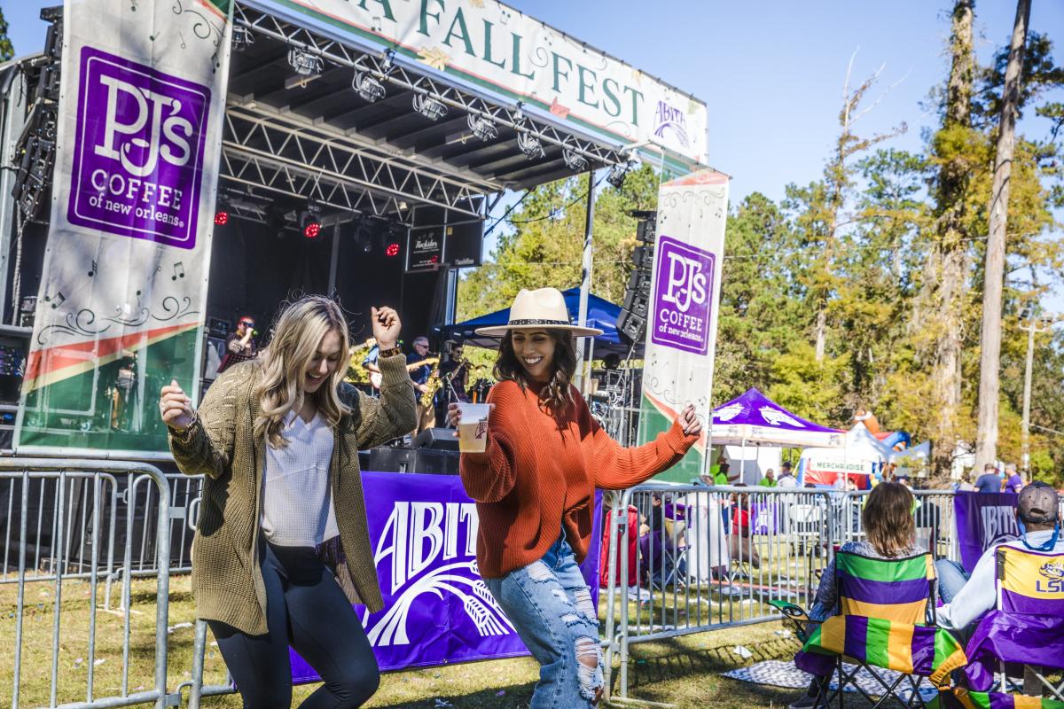 Two women dance beside the stage at Abita Fall Fest.