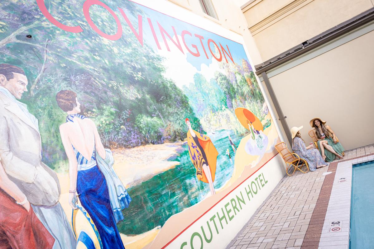Southern Hotel's poolside Covington mural and guests