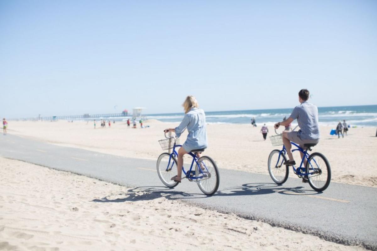 Couple biking on beach in Huntington Beach