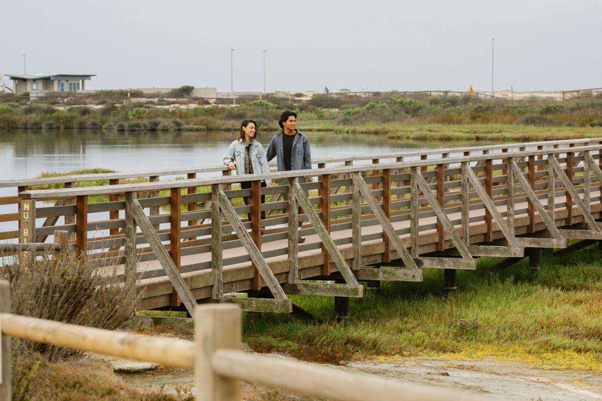 Bolsa Chica Ecological Reserve. Male & Female on a bridge looking out.