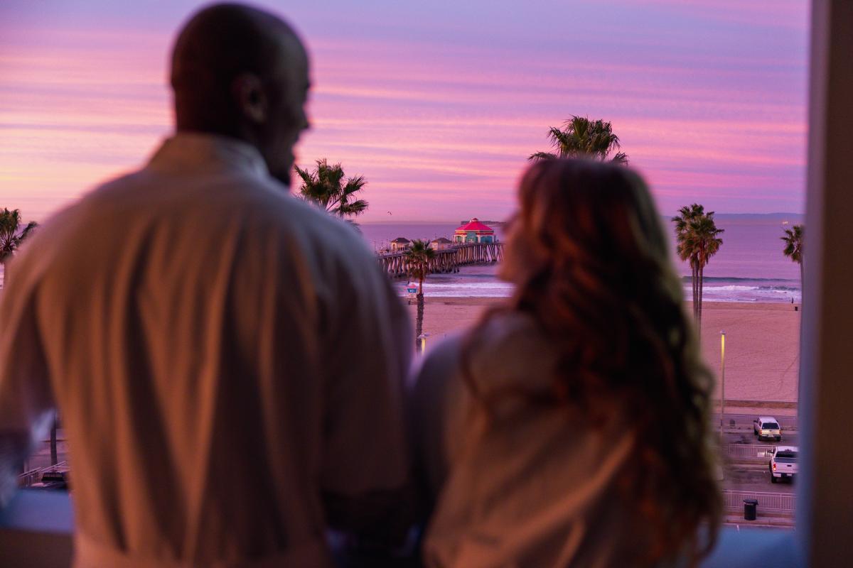 Couple on the balcony at sunrise Huntington Beach in Kimpton Shorebreak Resort