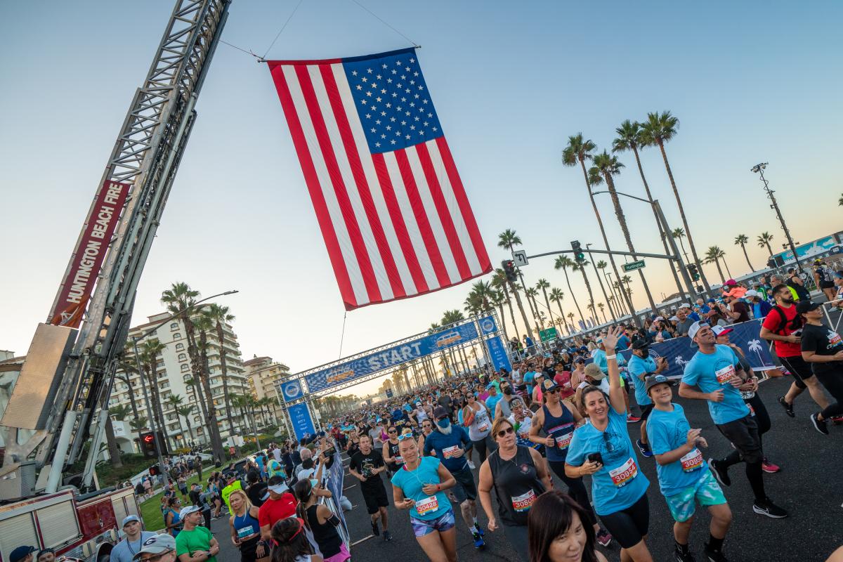 Surf City Marathon Start Line with Runners and an American Flag over the start line