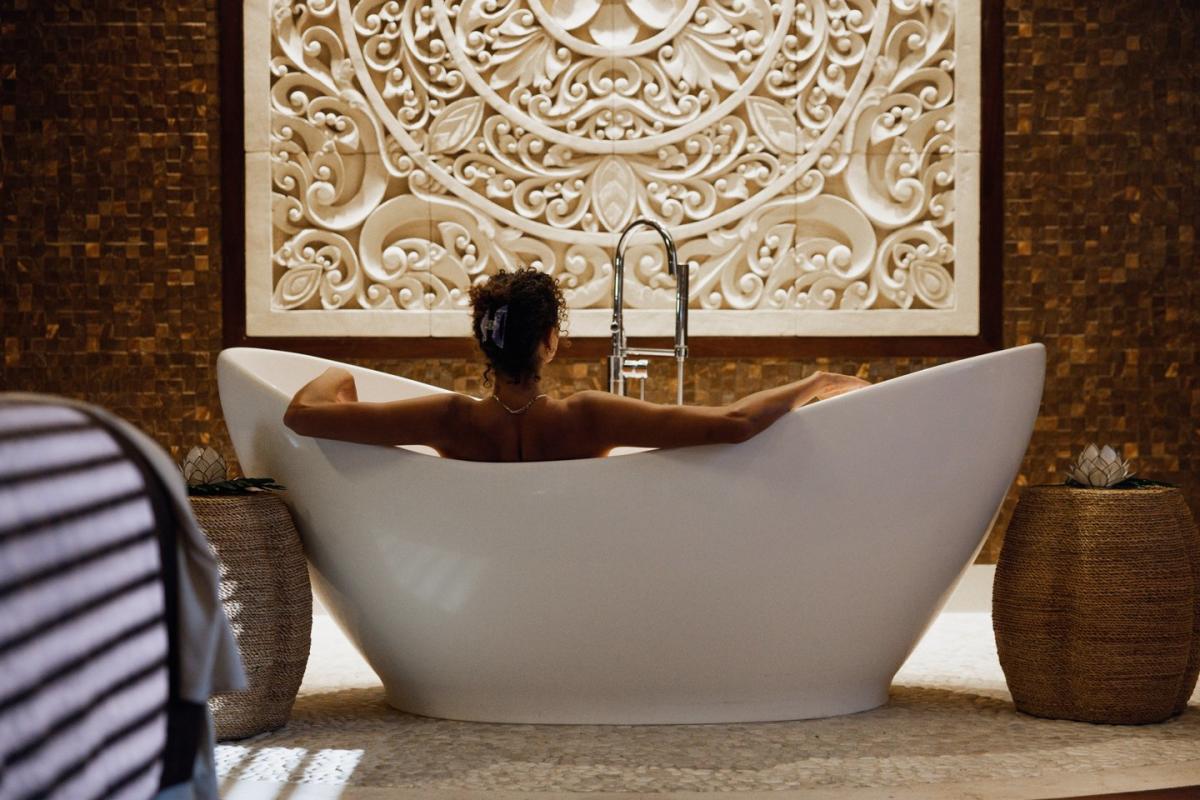 Aarna Spa. Image of a girl in a bathtub facing her back towards the camera