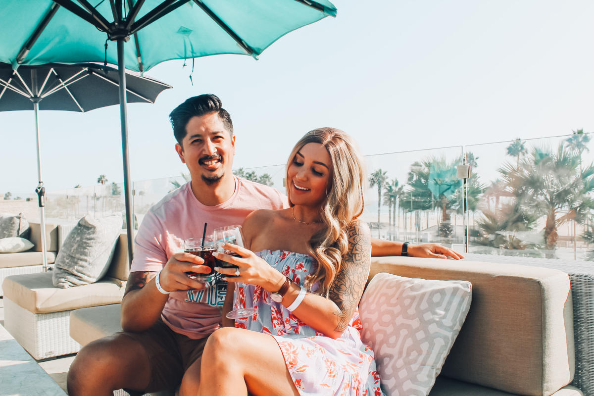 Smiling patrons enjoying drinks at Tanner's Rooftop Lounge in Huntington Beach