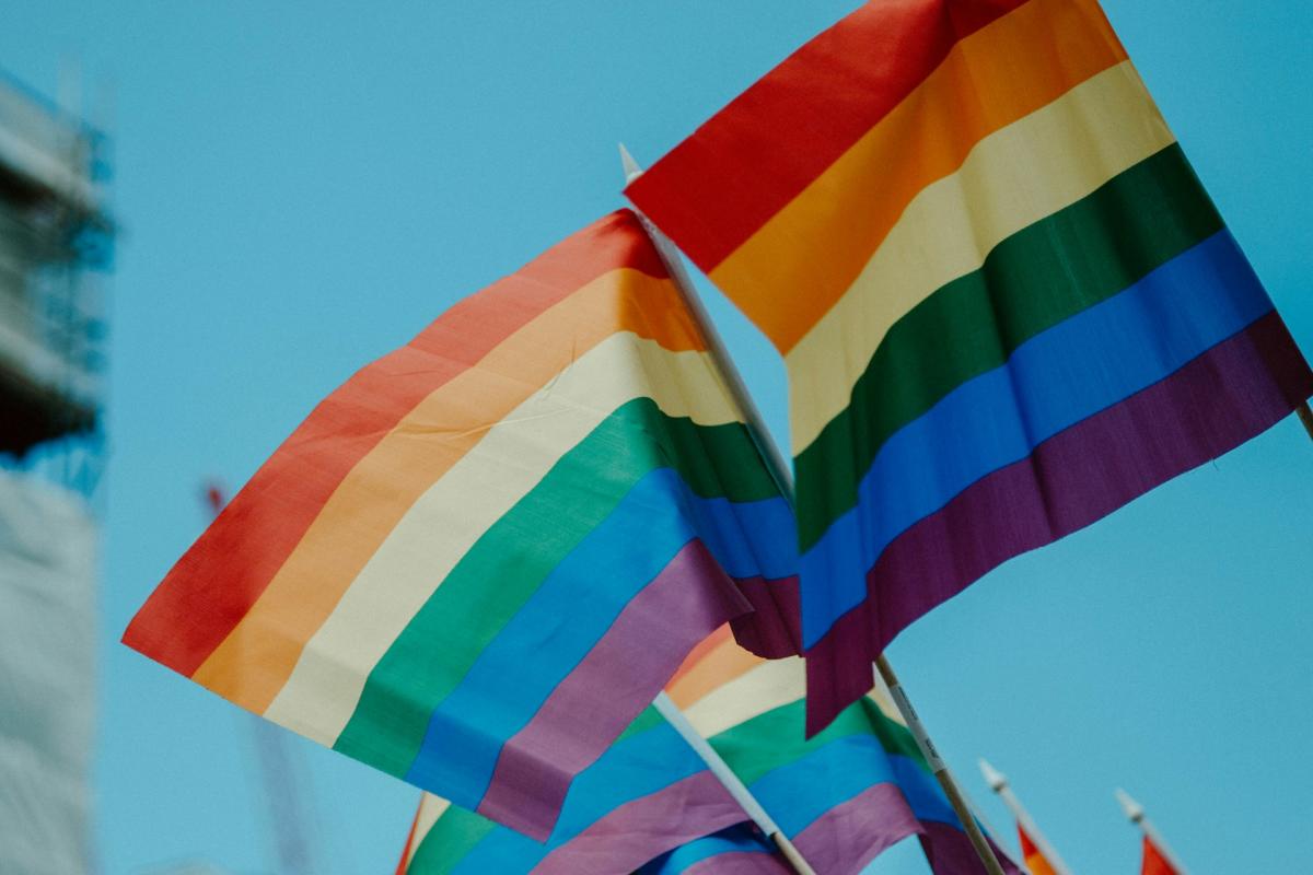 Two rainbow pride flags waving in the sky
