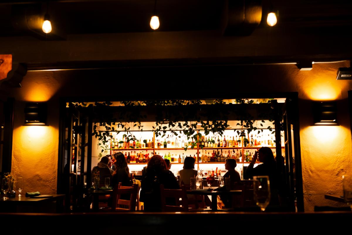 Silhouettes of people sitting in a restaurant at night.