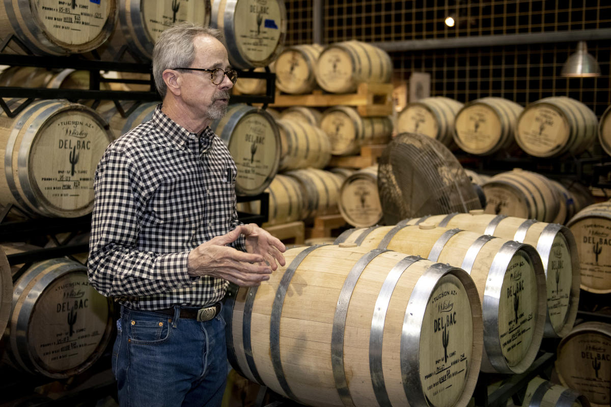 Stephen Paul, founder of  Hamilton Distillers, surrounded by large barrels of Whiskey Del Bac