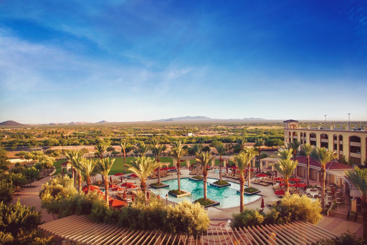 View from the Casino Del Sol balcony. Landscape shot looking over the bright pool , palm trees, and desert mountain range on horizon