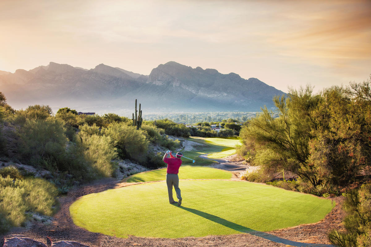 man in red shirt swinging golf club on Canada Course #9 at sunrise, El Conquistador Golf and Tennis