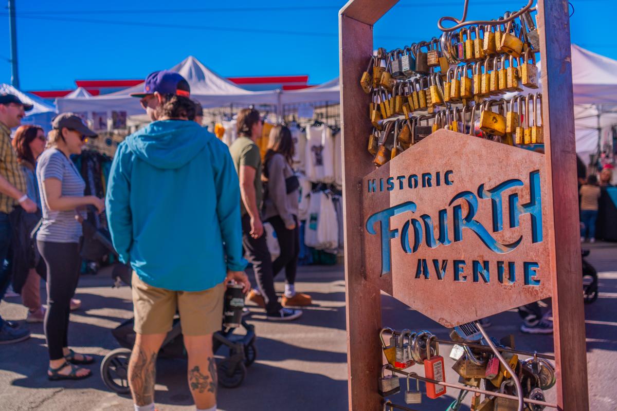 Bronze metal sign with locks in it that reads "Historic Fourth Ave"