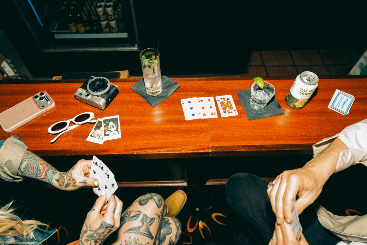 Two people playing cards at a bar