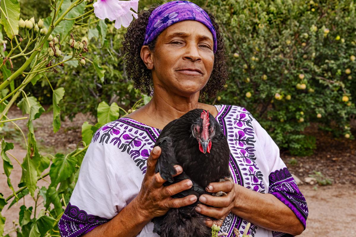 Portrait of a woman holding a chicken