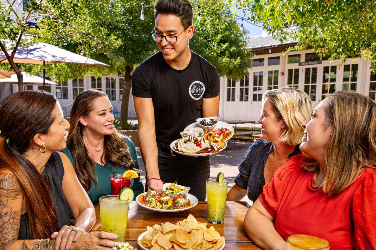 four women being served Mexican food at Seis at the Mercado in Tucson