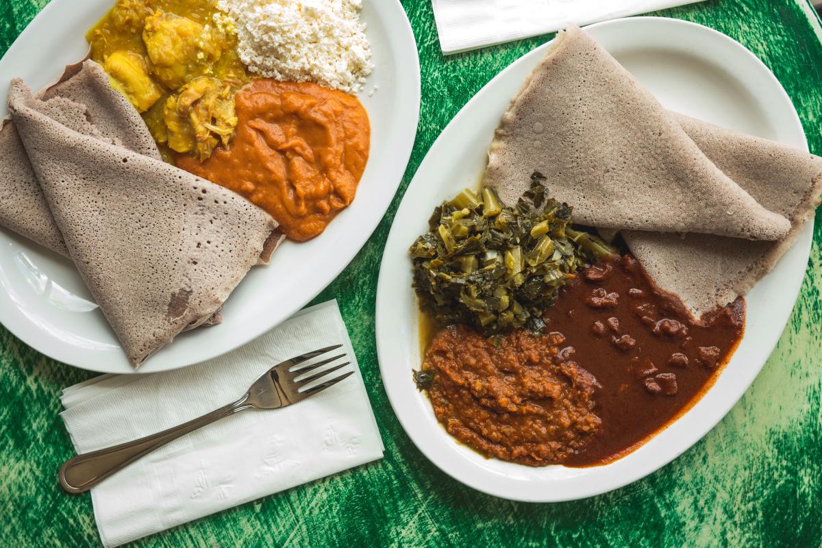 Two Plates of colorful Ethiopian Food plated on a green table