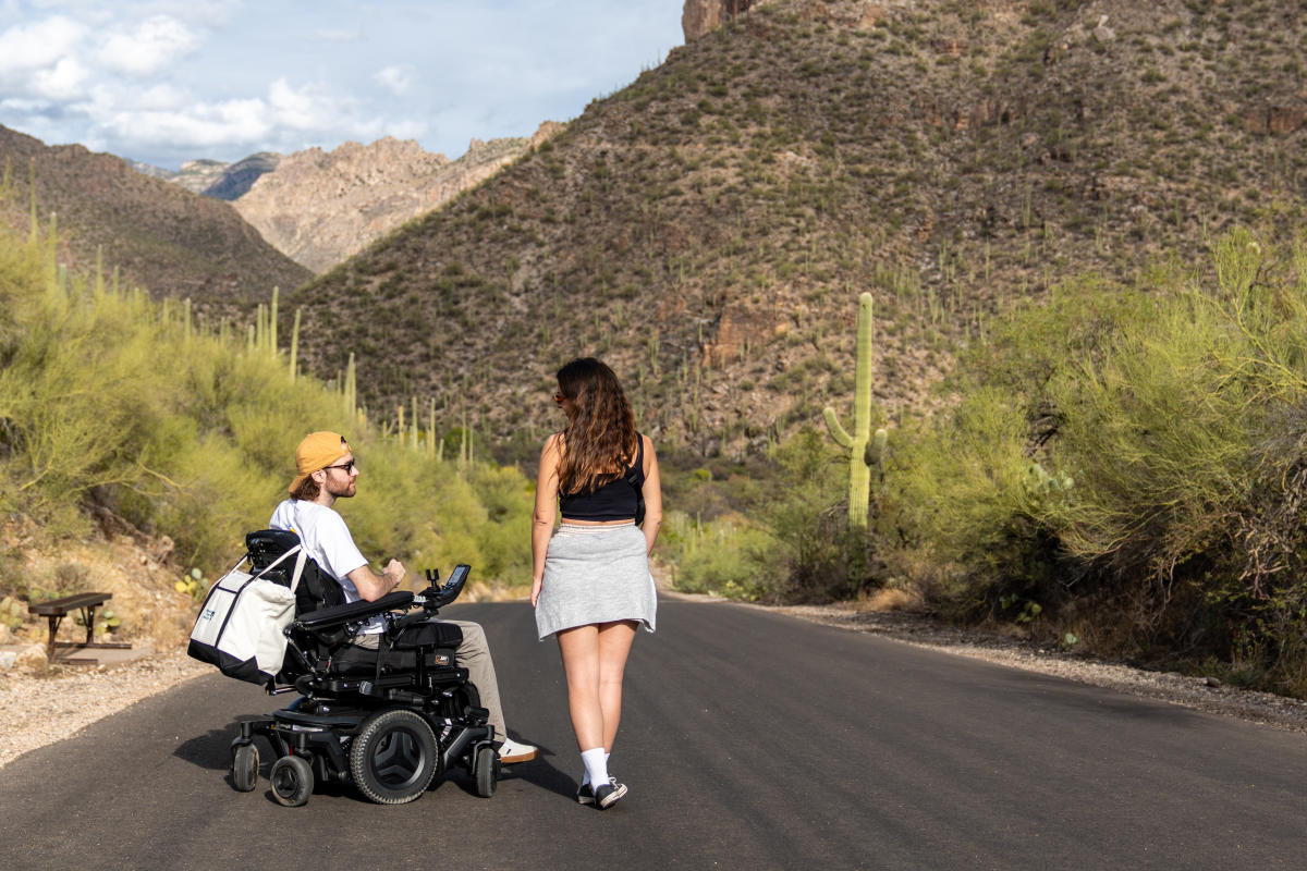 woman standing next to a man in a wheelchair in the desert at Sabino Canyon Tucson