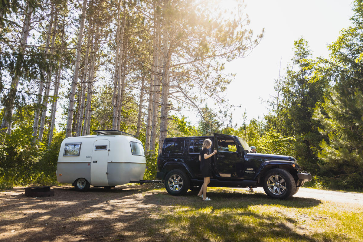 Couple with Jeep pulling small trailer at a campground