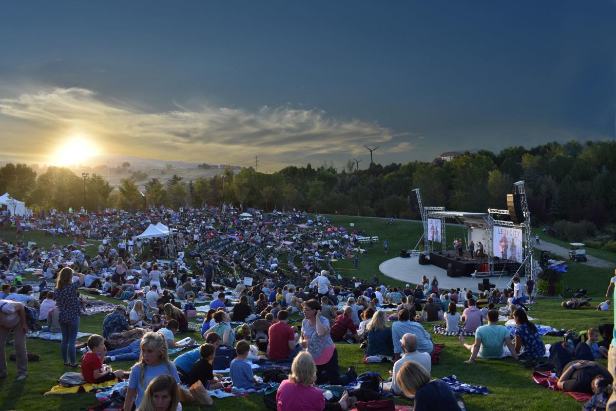 Crowd of people in gardens watching a show
