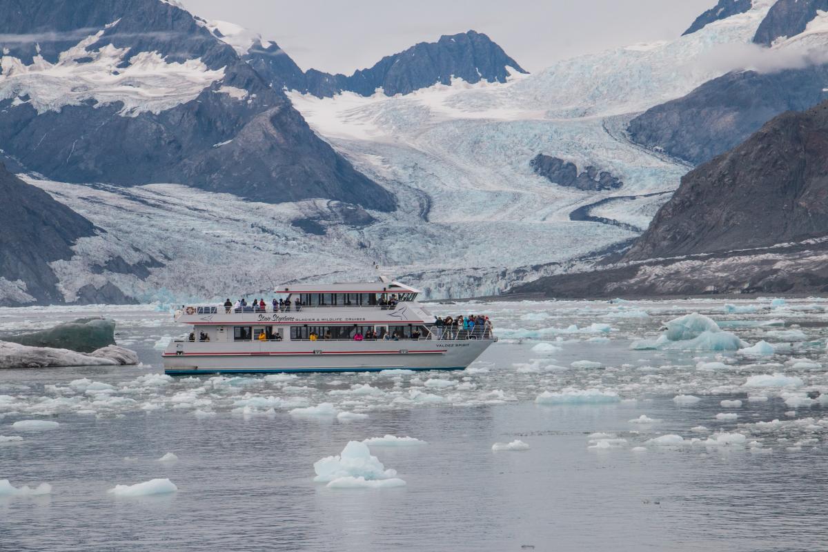 a cruise boat in a glacier bay facing a tidewater glacier