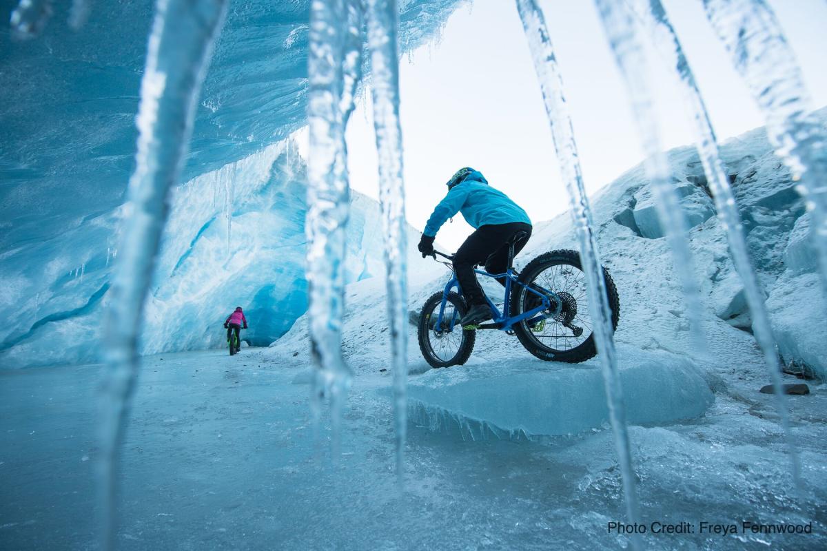 Fat bike riders ride through an ice cave