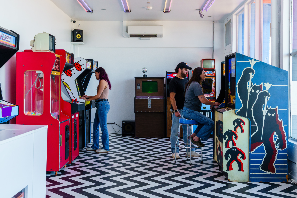 Friends and families playing retro arcade games at Hi-Orbit Games in Twentynine Palms, California.