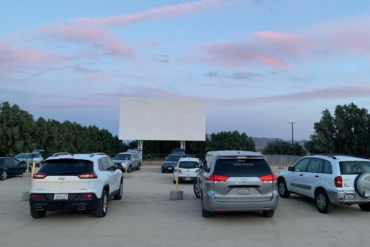 Vehicles parked beneath the screen at Smith's Ranch Drive-In in Twentynine Palms, California.