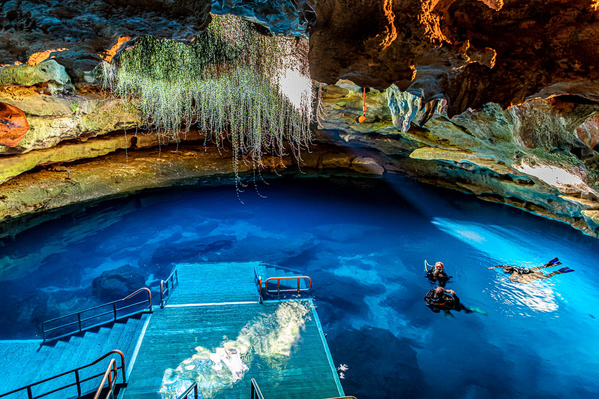 View from inside Devil's Den with three scuba divers.