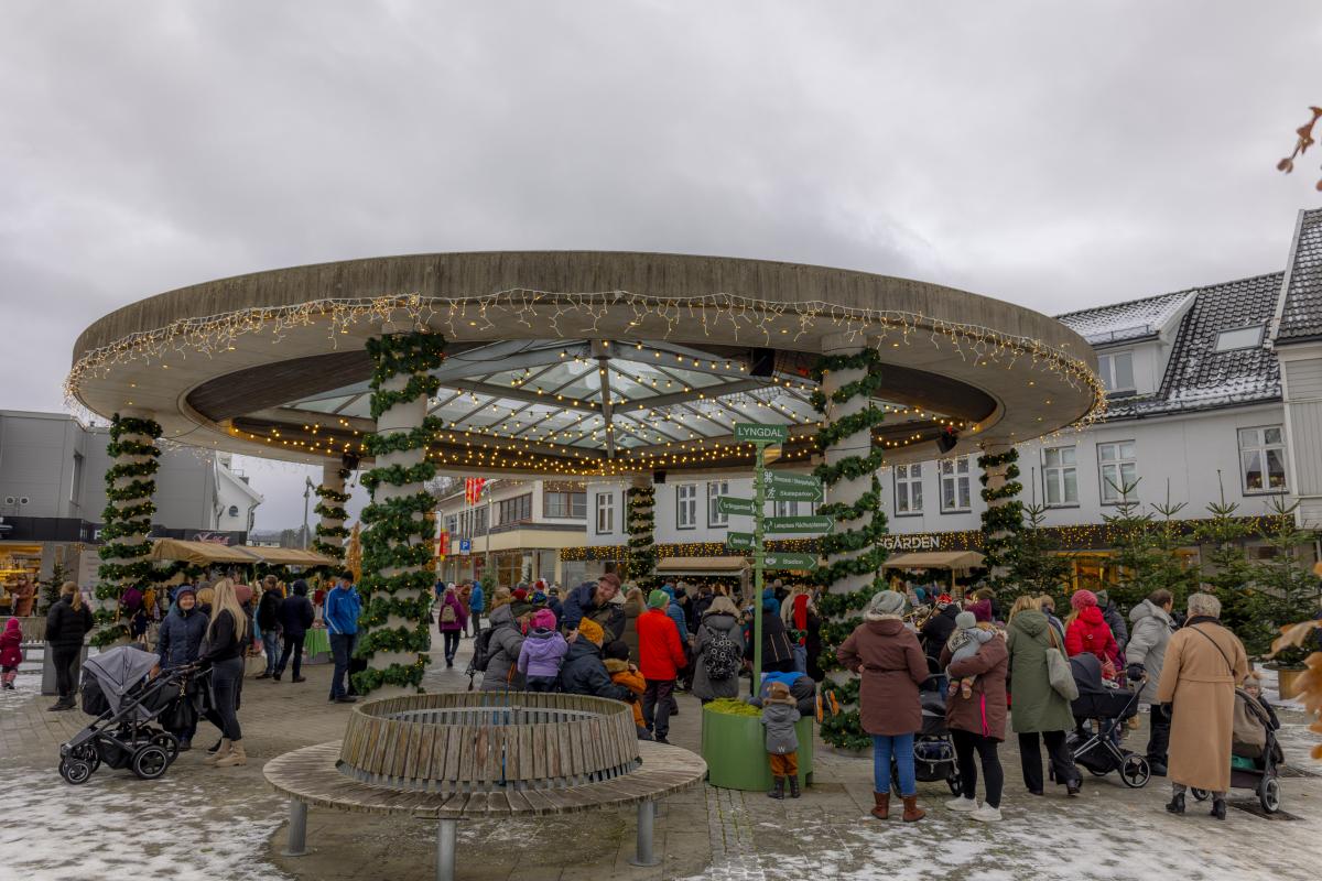 Bilde av folkemengde under den julepyntede paviljongen i Lyngdal sentrum.