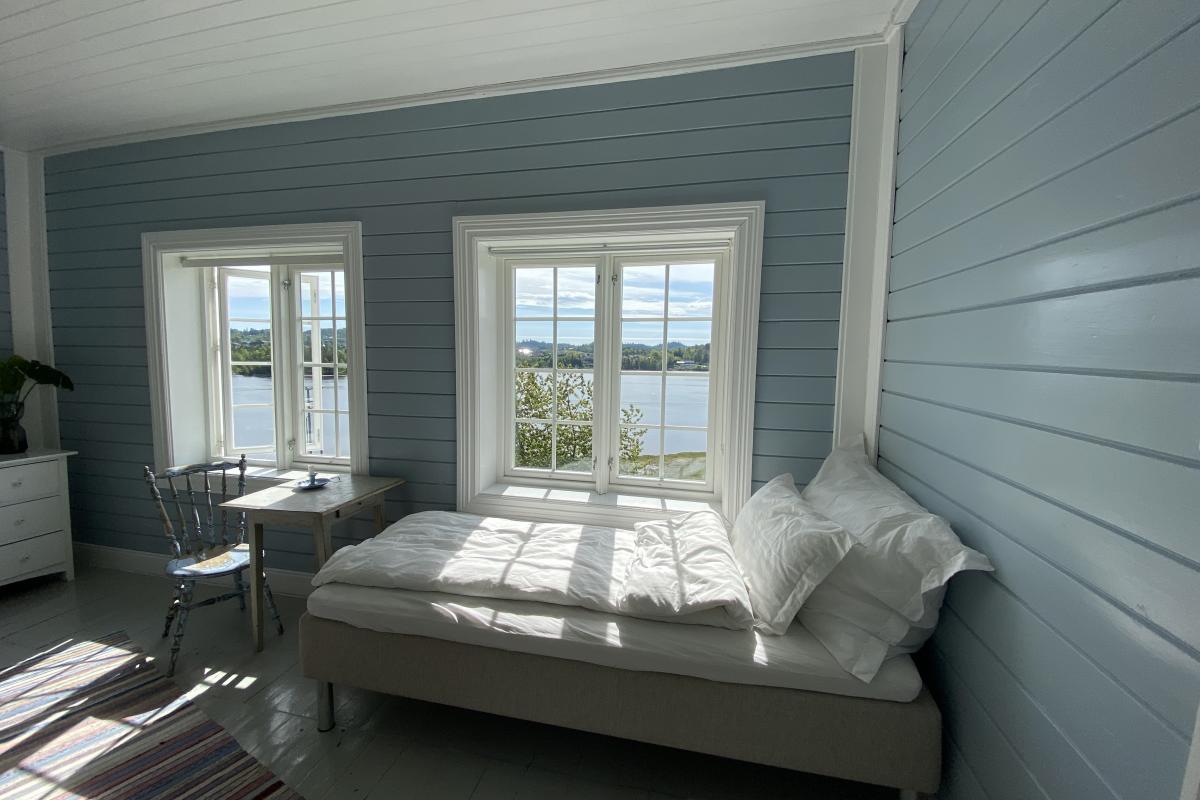 Soverom med seng og to vinduer