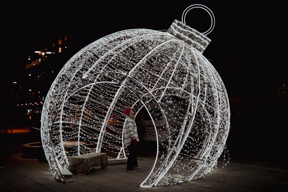 Kvinne står i en stor julekule av lys