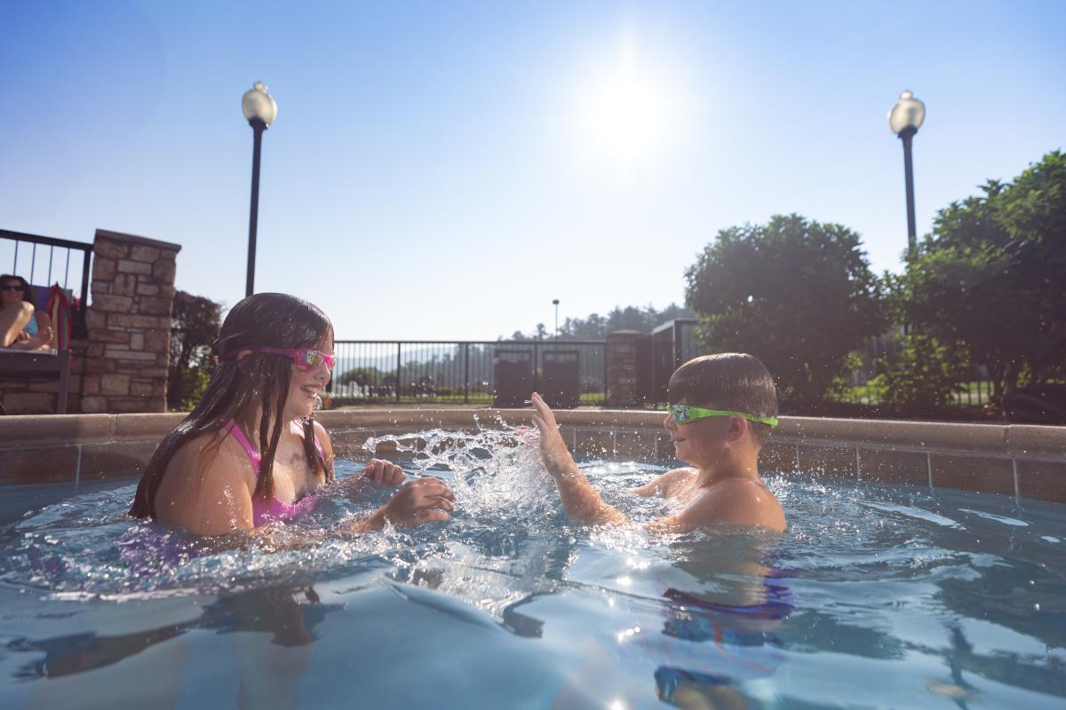 A brother and sister swimming in a pool at The Holiday Inn Resort