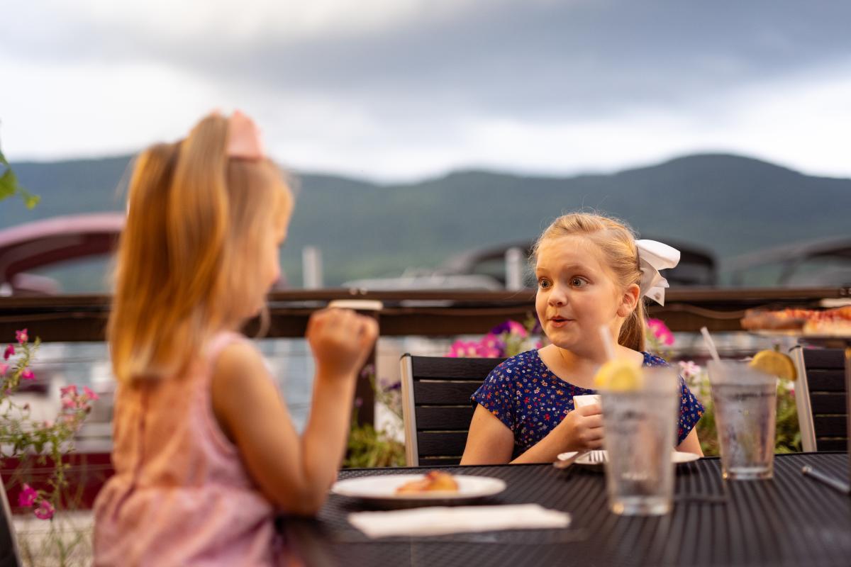 Two girls eating dinner at The Lagoon with a view of Lake George