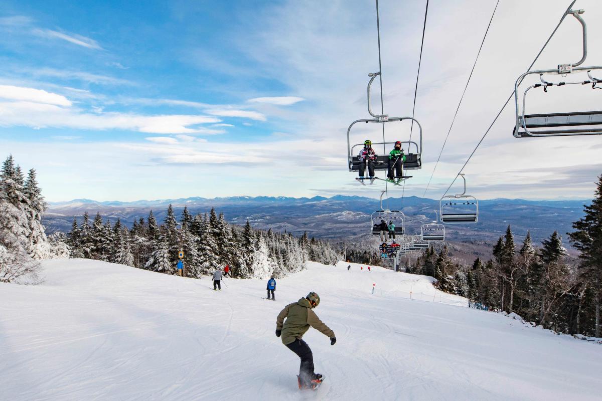 Adult Man Snowboarding Down a Ski Trail