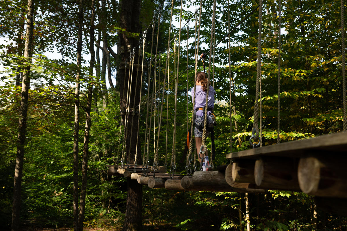 Girl going through an aerial course at Adirondack Extreme