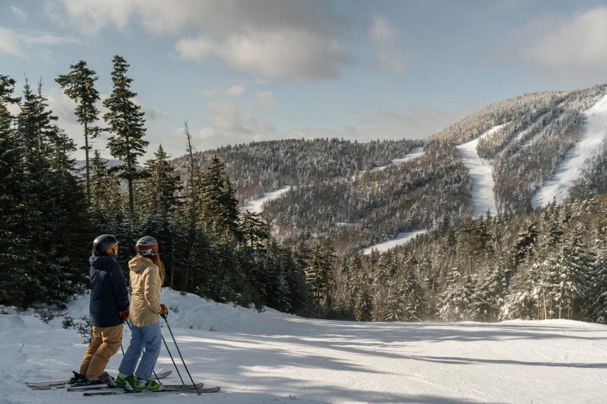 Couple on skis looking up at the ski trails