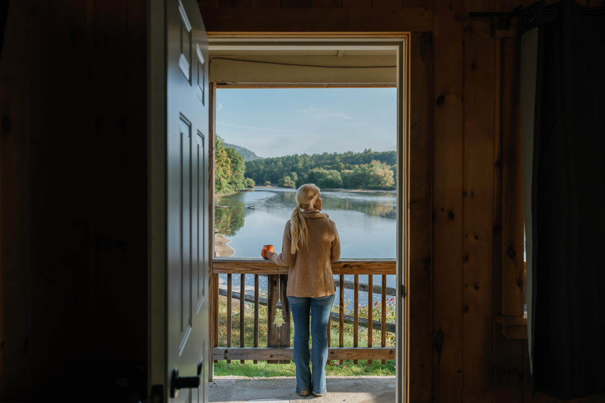 Woman standing on a porch of a cabin at 1000 Acres Ranch
