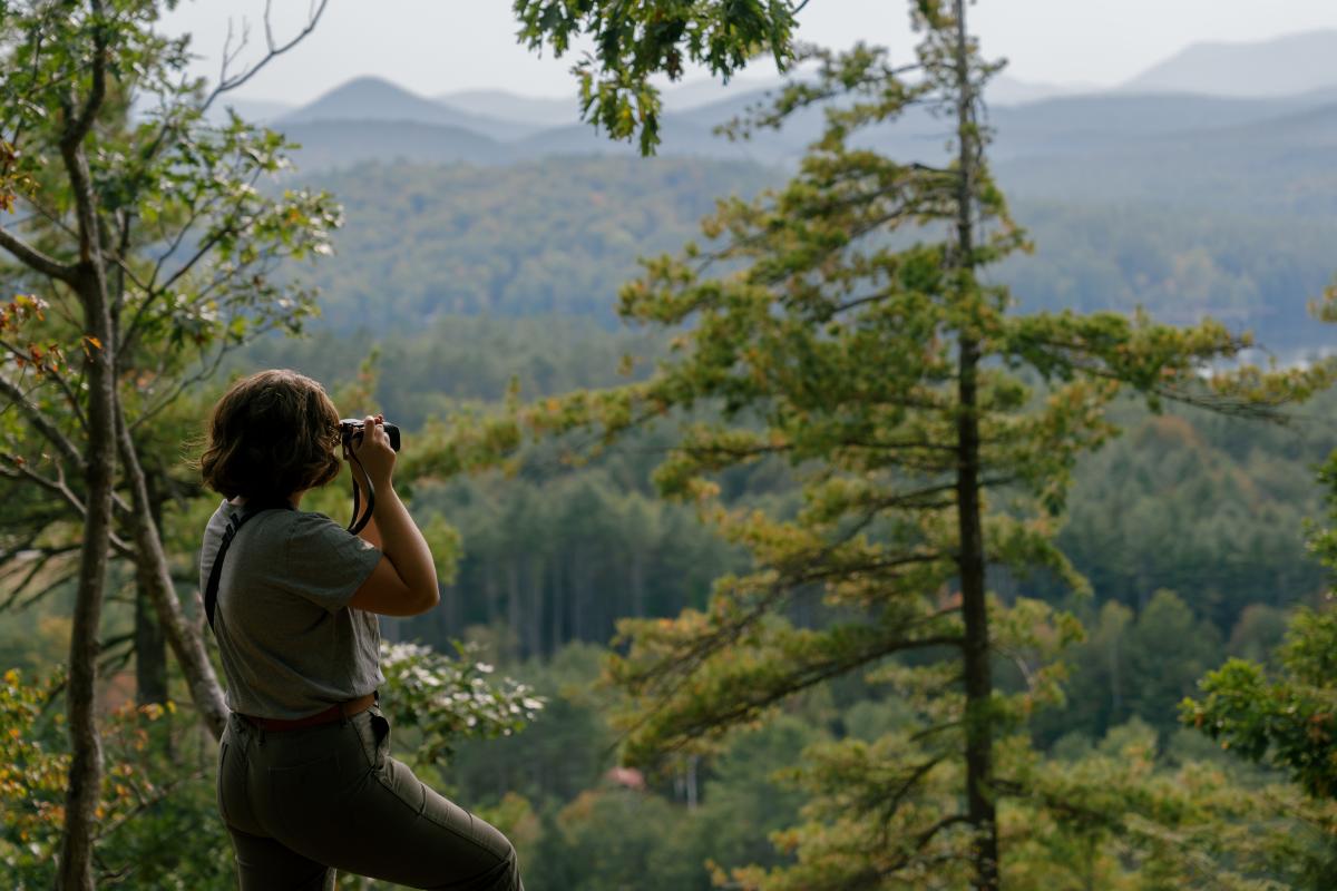 Hiker taking a picture on the summit of Stewart Mountain Hiking Trail